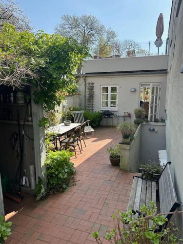 a patio with a table and benches in a backyard at I hjertet af Tønder by in Tønder