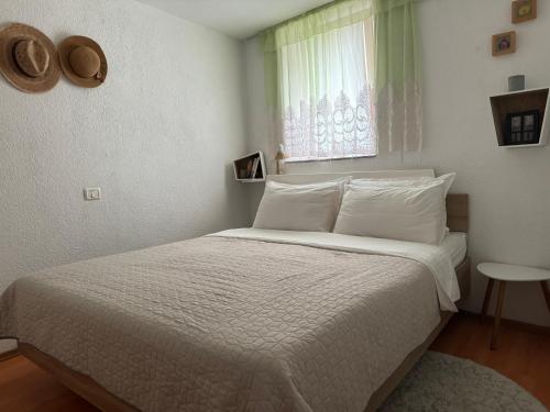 um quarto com uma cama com lençóis brancos e uma janela em Cozy Holiday Apartment em Izola