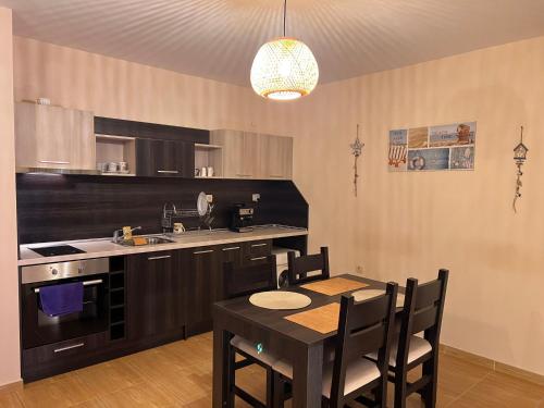 a kitchen with a table and a dining room at Sveti Vlas Sky Dreams Apartment in Sveti Vlas