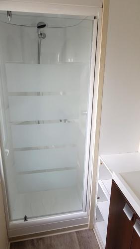 un réfrigérateur en verre dans une cuisine avec sa porte ouverte dans l'établissement Mobilhome 6 personnes, à Vic-la-Gardiole