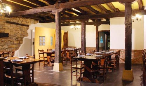 een eetkamer met houten tafels en stoelen bij Hotel Errekalde in Lezo