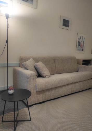 a living room with a couch and a table at LFSUITE LuganoLake Terrazza Spiaggia privata Parking WI-FI Netflix in Porlezza