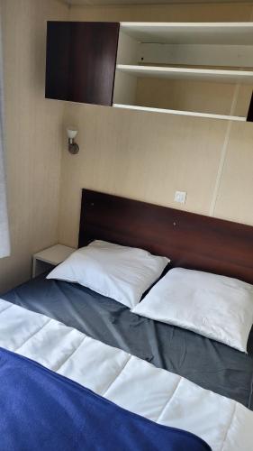 un lit avec deux oreillers dessus dans une chambre dans l'établissement Mobilhome 6 personnes, à Vic-la-Gardiole