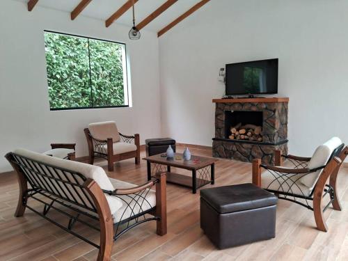 sala de estar con sillas y chimenea con TV en Casa de Campo Villa Azul Cañete, en Imperial