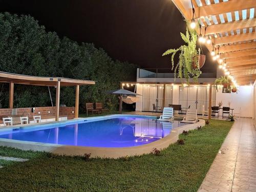 a swimming pool in a backyard at night at Casa de Campo Villa Azul Cañete in Imperial