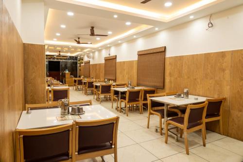 a restaurant with tables and chairs in a room at Rameswaram Harish Palace in Rāmeswaram