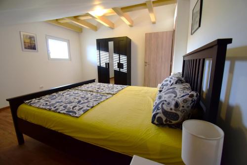 una camera da letto con un letto e un piumone giallo di Apartmani Barba a Rogoznica (Rogosnizza)