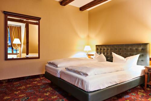a bedroom with a large bed and a mirror at Bernsteinschloss in Wendorf