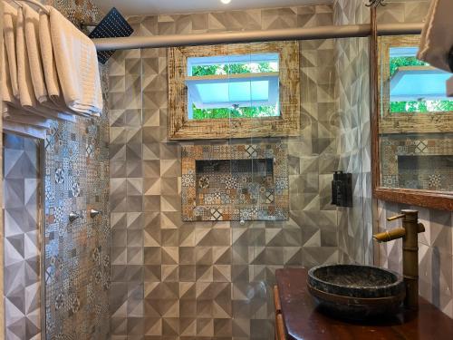 a bathroom with a shower with tiled walls and windows at Fazenda do Rosa in Praia do Rosa