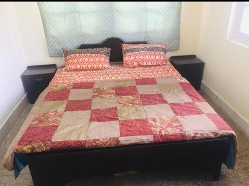 a bedroom with a bed with a quilt on it at Marry House in Murree