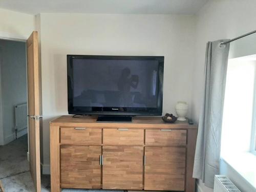 ein Flachbildfernseher auf einer Holzkommode in der Unterkunft Beautiful countryside cottage, sleeps 6, dogs welcome in Halifax
