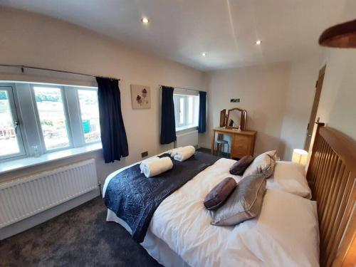 ein Schlafzimmer mit einem großen Bett mit Kissen darauf in der Unterkunft Beautiful countryside cottage, sleeps 6, dogs welcome in Halifax