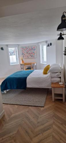 a bedroom with a large bed with a blue blanket at The Undercroft - central Leamington in Leamington Spa