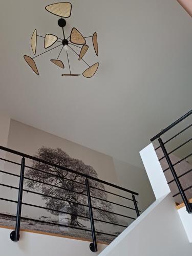 un escalier avec une peinture d'un arbre sur le mur dans l'établissement Maison de Vacances - vue panoramique rivière, à Ornans