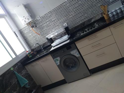 Ochenene的住宿－Résidence ElBoustani，一间厨房,在房间内配有洗衣机和烘干机