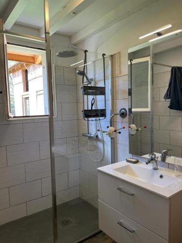 une salle de bain avec une douche et un lavabo et un lavabo dans l'établissement Logement à castex, à Castex
