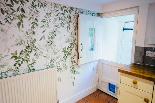 a kitchen with green leaves on the wall at Leam Terrace Escape in Leamington Spa