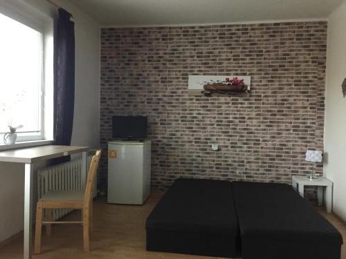 una sala de estar con una pared de ladrillo y un otomano negro en OLD TOWN and SIGHTSEEING STUDIO, en Košice