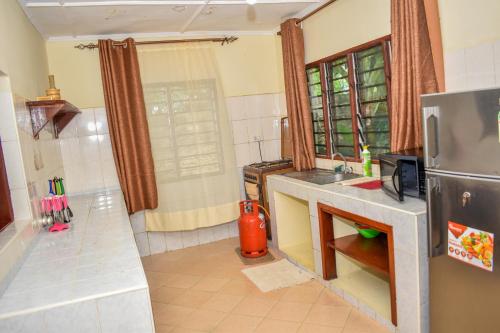 a kitchen with a sink and a refrigerator at Karura and friends airbnb (affordable) in Ukunda