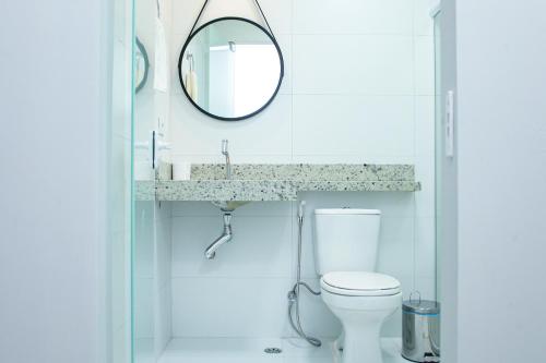 a white bathroom with a mirror and a toilet at Hotel Solar Paulista in Sao Paulo