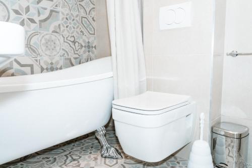 a bathroom with a white toilet and a bath tub at Historic Seafront Family Villa in Rafailovici