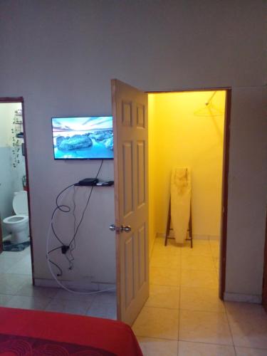 a room with a white door and a television at The Kozy Kotch in Montego Bay
