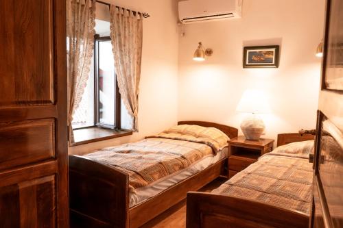 a bedroom with two beds and a window at Historic Seafront Family Villa in Rafailovici