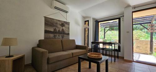 een woonkamer met een bank en een tafel bij Caseddu T2 N 14, Alba Rossa avec Piscine Chauffée in Serra-di-Ferro