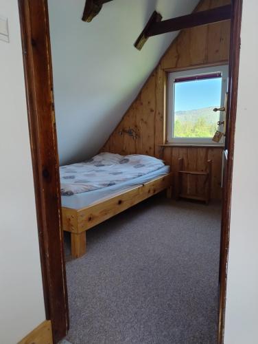 a bedroom with a bed in a room with a window at Podołynia in Dwernik
