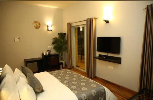 um quarto com uma cama e uma televisão de ecrã plano em Luxury Haven. Harmony Suites. em Vrindavan