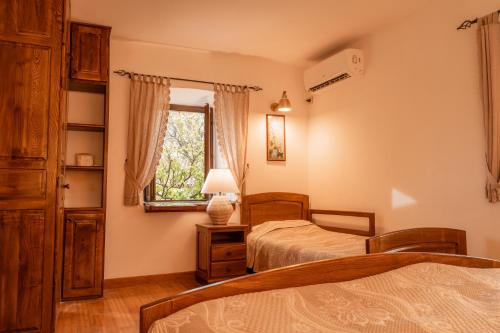 a bedroom with two beds and a window at Historic Seafront Family Villa in Rafailovici