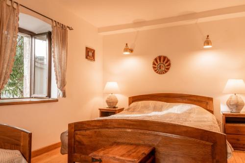 a bedroom with a wooden bed and a window at Historic Seafront Family Villa in Rafailovici