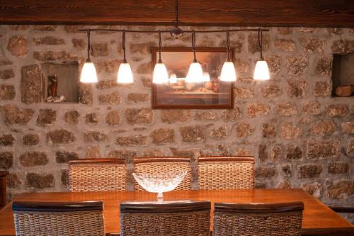 a dining room with a table with chairs and lights at Historic Seafront Family Villa in Rafailovici