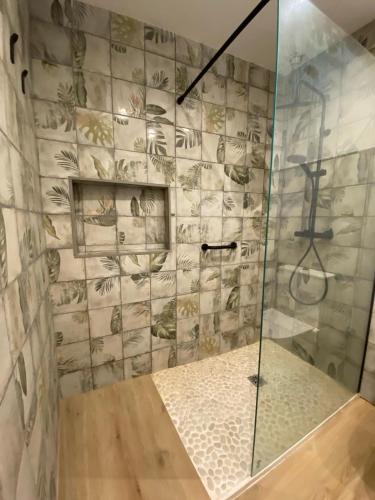 a shower with a glass door in a bathroom at Apartamento Guadalvivir in Mogón
