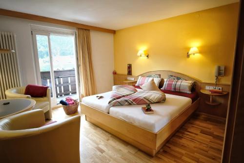 a hotel room with a bed and a chair at See-Apartments Kärntnerhof in Weissensee