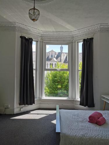 ein Schlafzimmer mit einem Bett und einem großen Fenster in der Unterkunft Freedom park villas room 1 in Plymouth