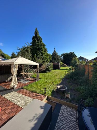 une arrière-cour avec un parasol et un grill dans l'établissement Urban oasis entire house 3 beds 2 living room expansive garden, à Eltham