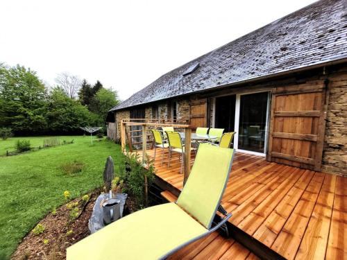 a deck with yellow chairs on a cabin at Gîte de France C'est tout vert 4 épis - Gîte de France 5 personnes MAE-9824 in Condat-sur-Ganaveix
