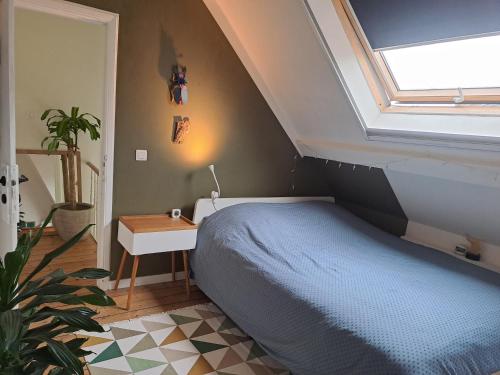 a bedroom with a blue bed and a window at Charming house in Ghent in Ghent