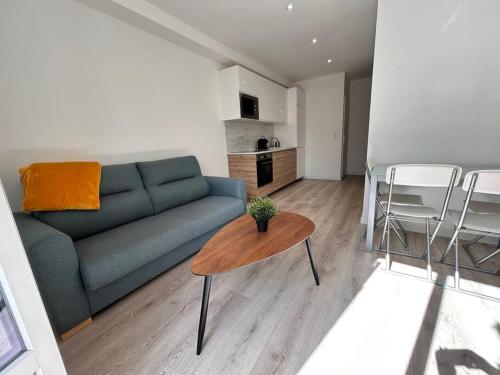un salon avec un canapé bleu et une table dans l'établissement Mia- 4 pers- Standing Neuf, Hyper centre- Terrasse, à Saint-Raphaël