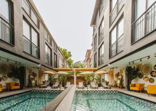 a swimming pool between two buildings with chairs and tables at Ella Suites Hotel in Antalya