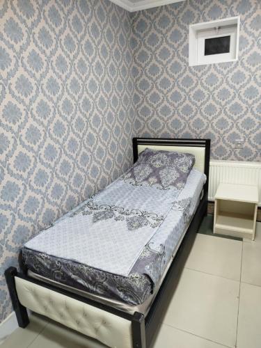 a bedroom with a bed in a room with wallpaper at Quba ALFA-M Motel in Quba
