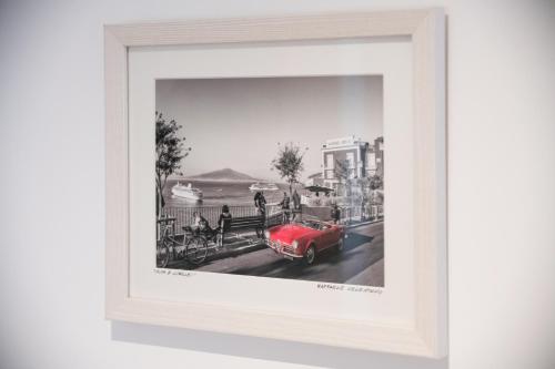 a black and white photo of a red car on a street at Elenì Sorrento in Sorrento