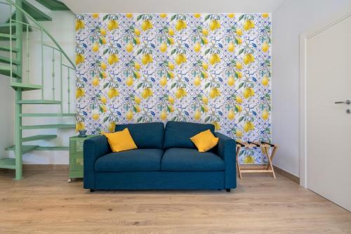 a blue couch in a living room with a floral wallpaper at Elenì Sorrento in Sorrento