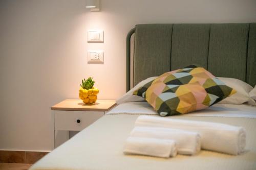 a bed with a pillow and a pineapple on a night stand at Elenì Sorrento in Sorrento