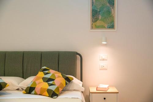 a bed with a green headboard and a side table at Elenì Sorrento in Sorrento