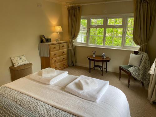 a bedroom with a large white bed and a window at Huntleys Lodge in Ticehurst