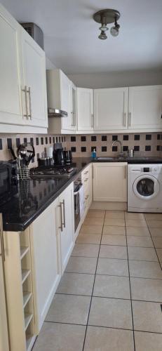 a kitchen with white cabinets and a tile floor at Holywood Town House in Town Centre in Holywood