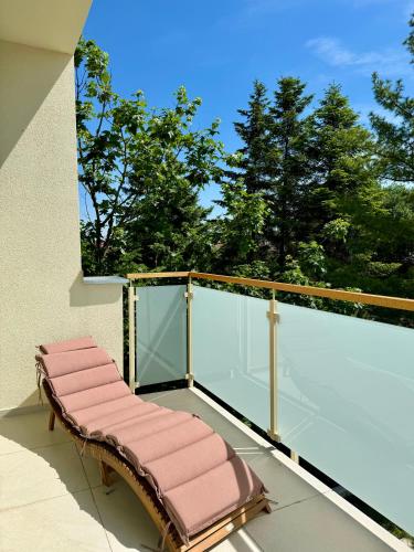 un banc sur le balcon d'un bâtiment dans l'établissement Apartment ZOi, à Šamorín