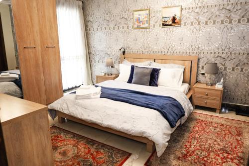 een slaapkamer met een groot bed en een tapijt bij Luxury hotel apartment with pools in front AUC in Caïro